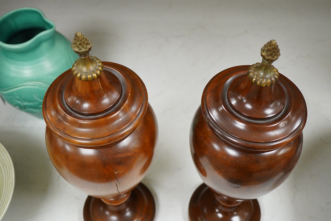 A pair of turned hardwood urns and covers, 42cm